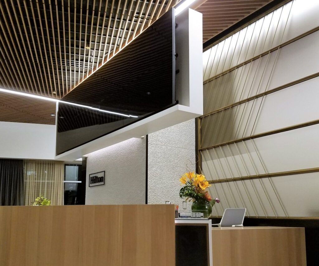 A from-below shot of a Hilton lobby with wood paneled walls and ceilings