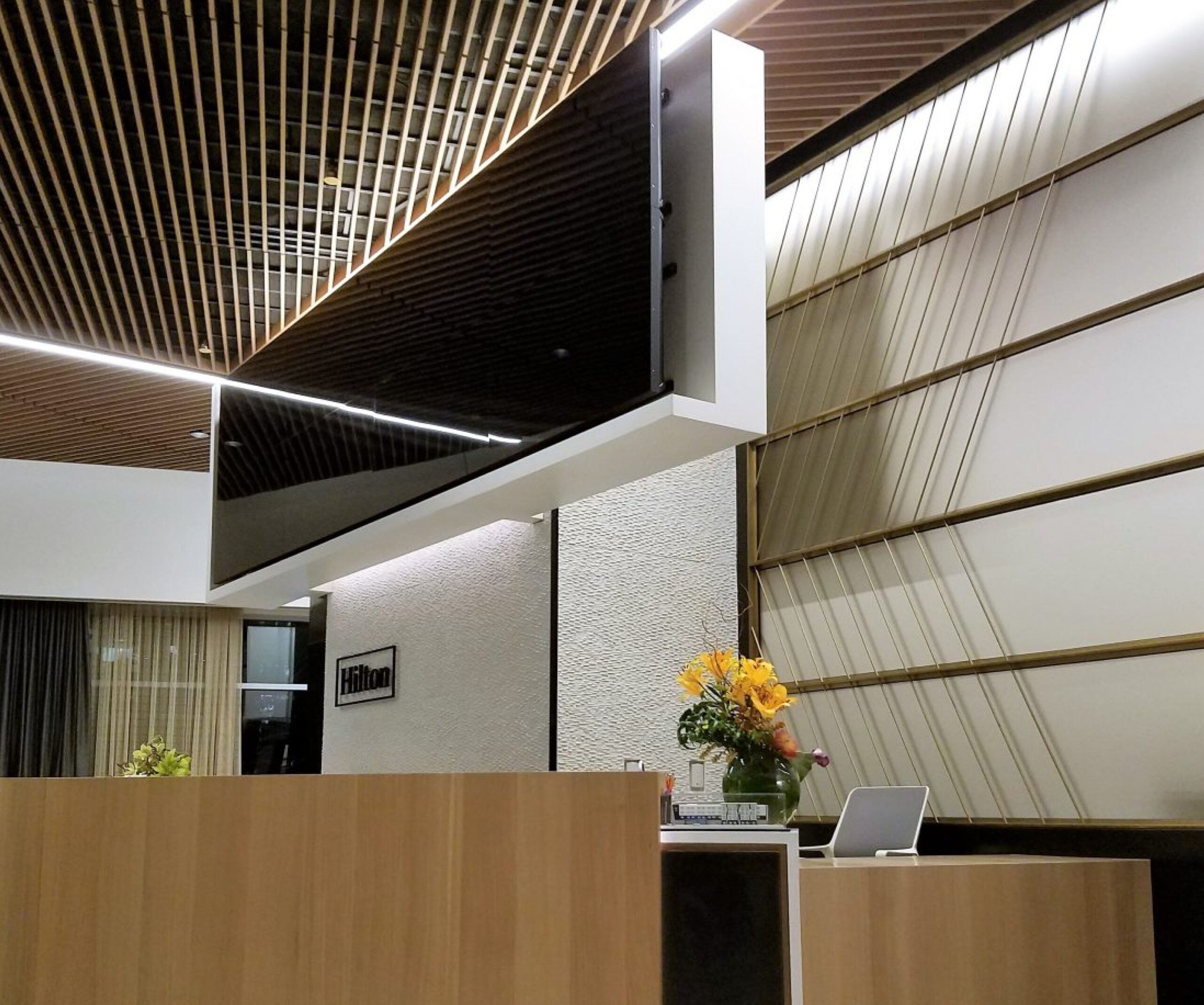 A from-below shot of a Hilton lobby with wood paneled walls and ceilings